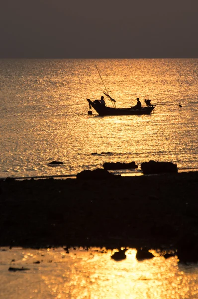 Fishing boat with fishermen at sunset — Stock Photo, Image