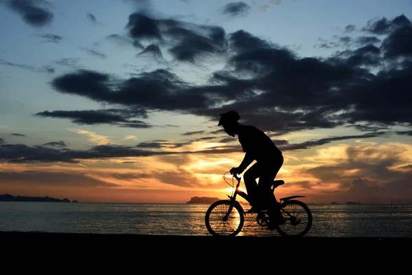 Silhouette dell'uomo con bicicletta sulla spiaggia — Foto Stock