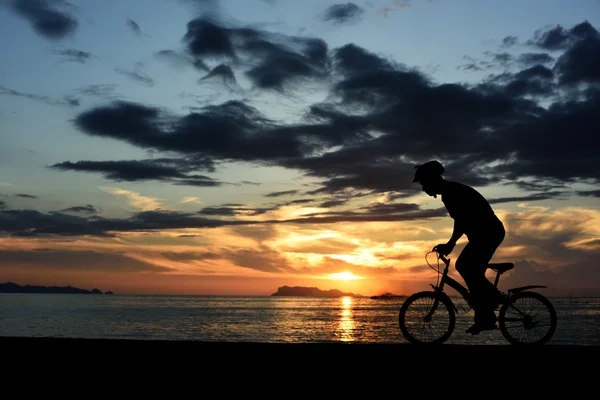 Silhouette dell'uomo con bicicletta sulla spiaggia — Foto Stock