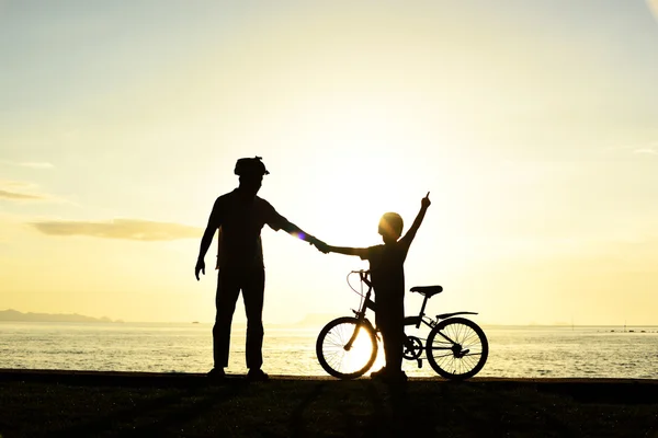 Padre e ragazzo con bicicletta sulla spiaggia — Foto Stock