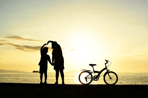 Мати і хлопчик з велосипедом на пляжі — стокове фото