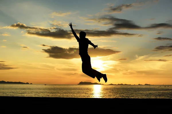 Silhouette of jumping man on beach — Stock Photo, Image