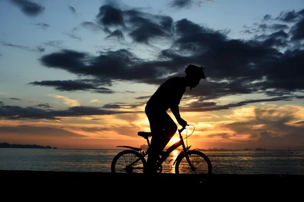 Silueta del hombre con bicicleta en la playa — Foto de Stock