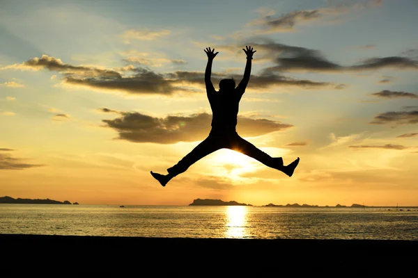 Silhouet van springen man op strand — Stockfoto