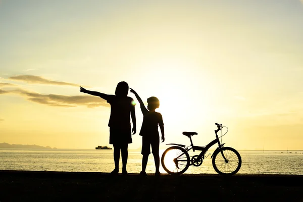 Mamma e ragazzo con bicicletta sulla spiaggia — Foto Stock