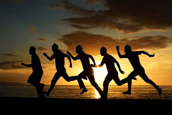 Sauter et courir des hommes sur la plage — Photo