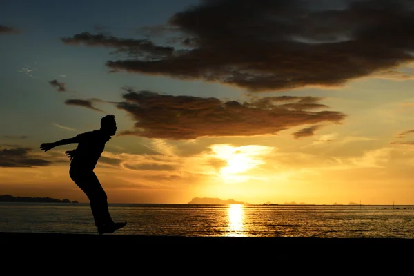 Silhouette di salto uomo sulla spiaggia — Foto Stock