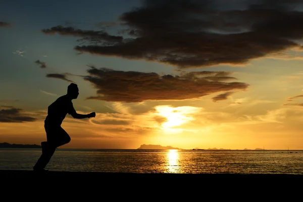 Silhouet van het runnen van man op strand — Stockfoto