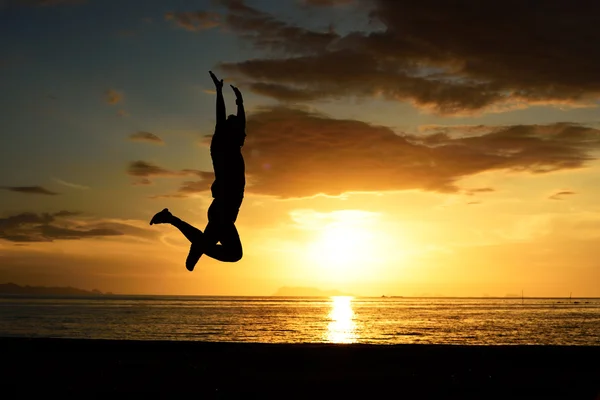 Silhouet van springen man op strand — Stockfoto