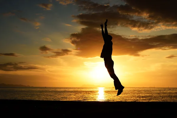 Silhouet van springen man op strand — Stockfoto