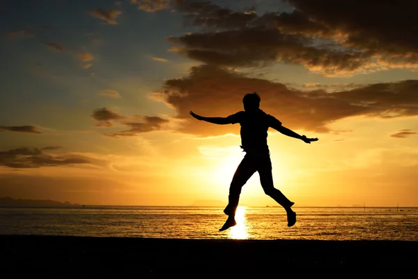 Силуэт прыгающего человека на пляже — стоковое фото