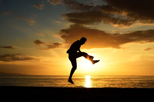 Silhouette di salto uomo sulla spiaggia — Foto Stock