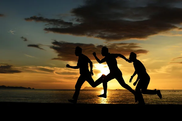 Pulando e correndo homens na praia — Fotografia de Stock