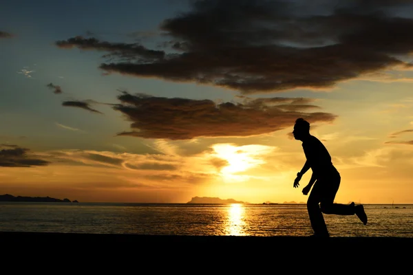 Sziluettjét futó ember, a strandon — Stock Fotó