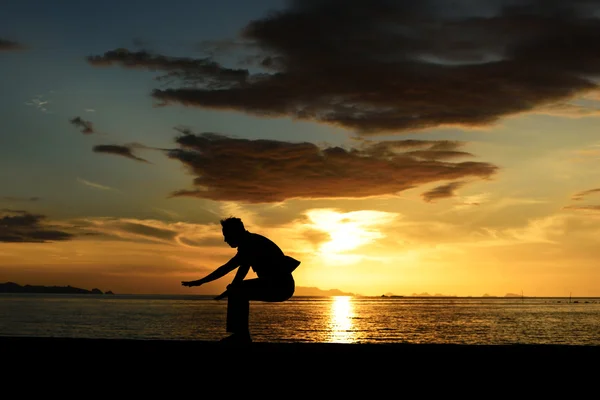 Silhouette di salto uomo sulla spiaggia — Foto Stock