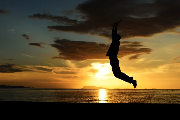 Silhuett av hoppar man på stranden — Stockfoto