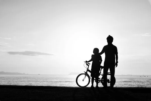 Pai e menino com bicicleta na praia — Fotografia de Stock