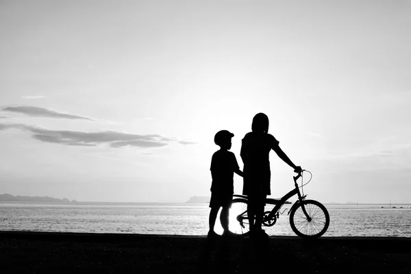 Mother and boy with bicycle on beach — Stock Photo, Image