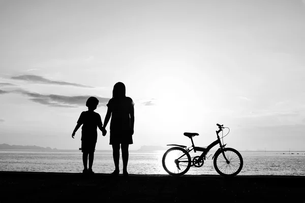 Mamma e ragazzo con bicicletta sulla spiaggia — Foto Stock