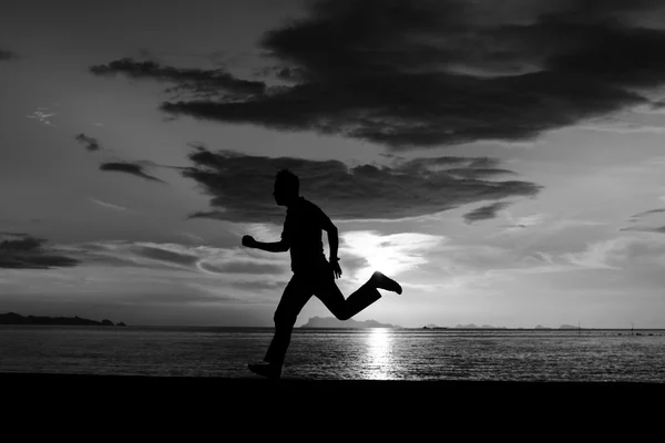 Silhueta de homem correndo na praia — Fotografia de Stock