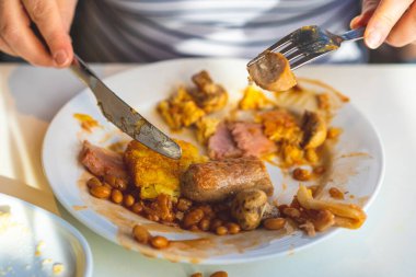 Restoranda geleneksel İngiliz kahvaltısı yiyen bir kadın. Tam İngiliz kahvaltısı omlet, sosis, ızgara domates, mantar, yumurta, pastırma, fırında fasulye, kahve, portakal esmer. 