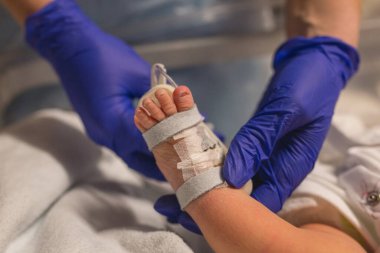 Coronavirus. Covid-19. Doktor yeni doğan bebeği kontrol ediyor. Aşı virüsü. Ebe yeni doğan bebeğe antibiyotik veriyor. Küçük bebek antikor kontrolü yaptırıyor. Hastanede yeni doğmuş bir bebek. Pandemik virüs. Sepsis.