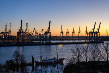 Hamburg, Almanya: Alacakaranlıktaki limandaki tersane vinçleri