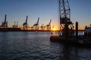 Hamburg, Almanya: Alacakaranlıktaki limandaki tersane vinçleri