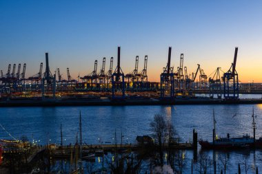 Hamburg, Almanya: Alacakaranlıktaki limandaki tersane vinçleri