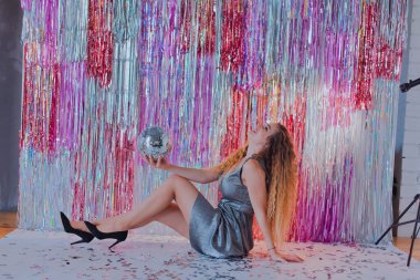 Yeni yıl mekanında parlak elbiseli bir kız.