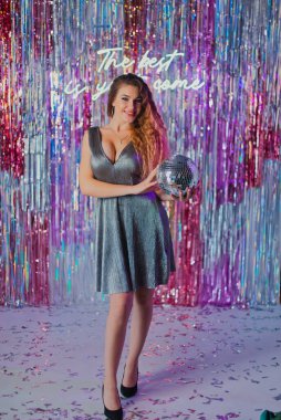 Yeni yıl mekanında parlak elbiseli bir kız.