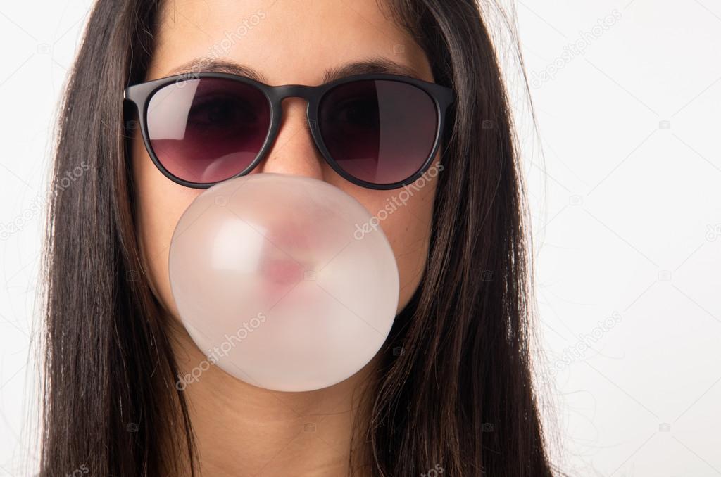 Girl with sunglasses blowing bubble gum