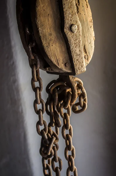 Polea vieja con cadenas oxidadas colgantes — Foto de Stock