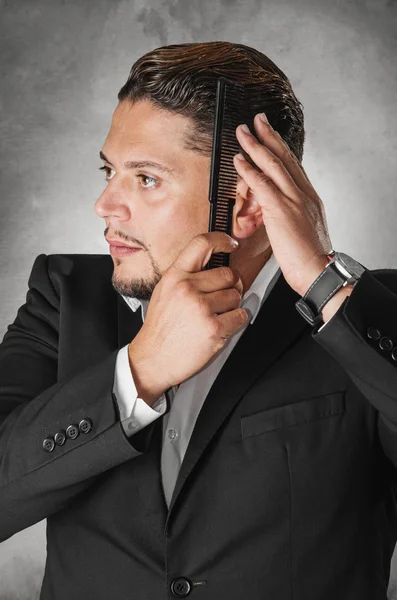 Elegante hombre peinándose el pelo —  Fotos de Stock