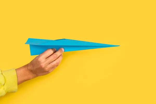 Mulher Mão Segurando Avião Papel Azul Fundo Amarelo — Fotografia de Stock