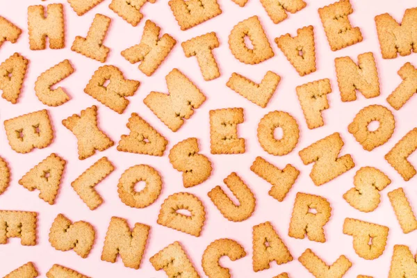 アルファベットのクッキーをピンクの背景に並べ替え — ストック写真