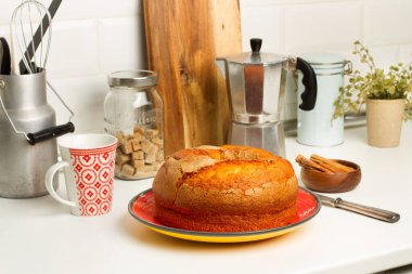 Mutfak tezgahındaki kırmızı tabakta vanilyalı kek.