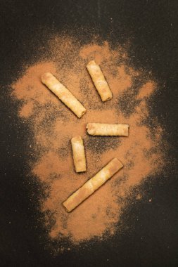 Kakao tozu katılmış gofret parçaları. Koyu bir arka planda, üstte.