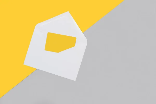 白色信封灰色和黄色背景上带有黄色卡片的带有复制空间的白色信封 — 图库照片