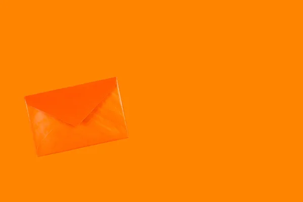 コピースペースのあるオレンジの背景のオレンジの封筒 — ストック写真
