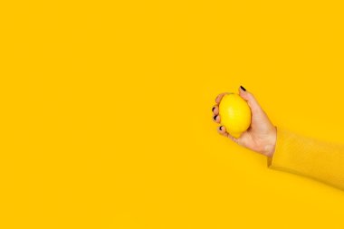 Kopya alanı olan sarı arka planda limon tutan kadın