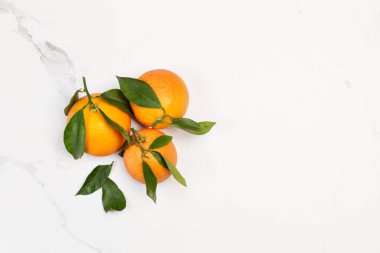 Mermer zemin üzerinde yeşil yapraklı portakallar