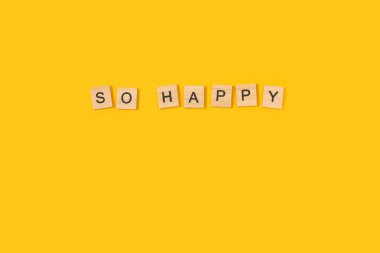 So happy write with wooden letter blocks on a yellow background