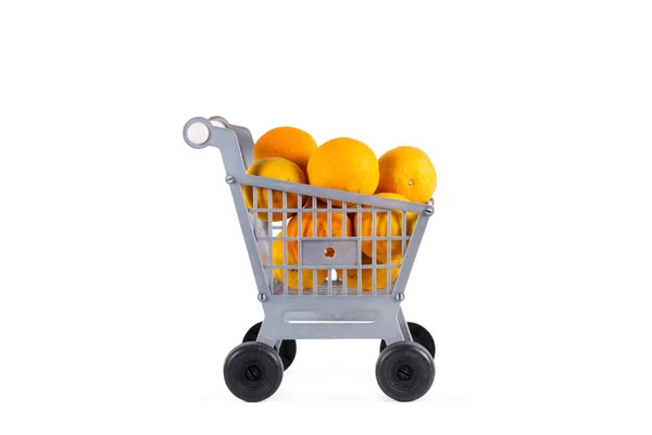 Een Plastic Speelgoedwinkelwagentje Met Sinaasappels Een Witte Achtergrond — Stockfoto