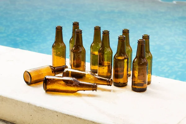 Yüzme havuzunun kenarında boş bira şişeleri