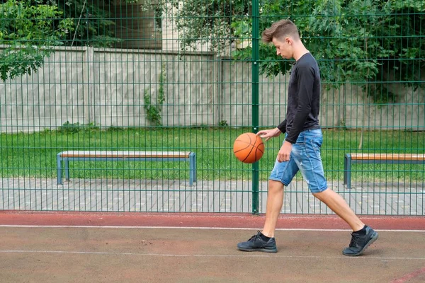 Utomhus porträtt av tonåring pojke spelar street basket, kopiera utrymme — Stockfoto