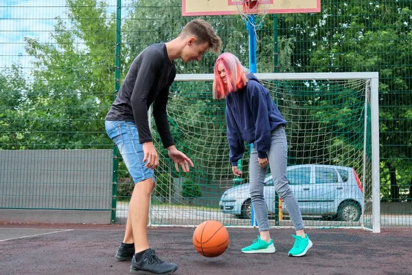 Teenagers boy and girl playing street basketball together — Stock Photo, Image