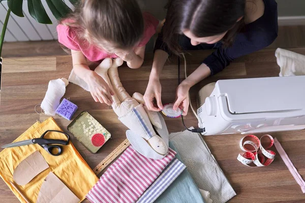Familia, dos niñas hermanas adolescente y más joven juntos coser juguete muñeca conejito — Foto de Stock
