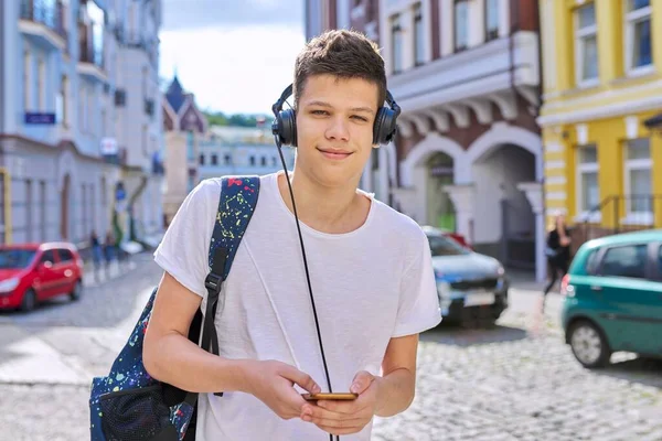 Портрет студента подростка с наушниками смартфон рюкзак, смотрящего в камеру — стоковое фото
