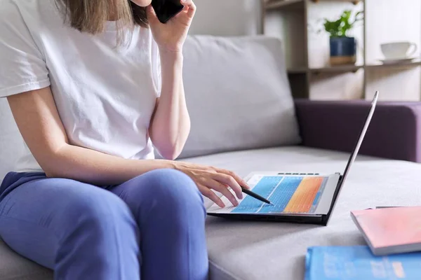 집에서 원격으로 일하는 젊은 여자가 노트북을 가지고 소파에 앉아 — 스톡 사진